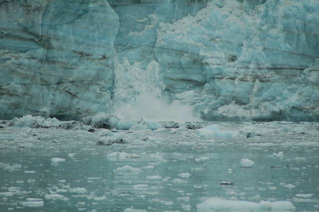 iceberg crumbles into water