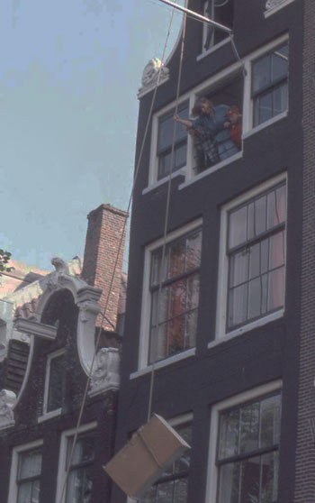 pulley being used to hoist furniture into narrow Dutch house