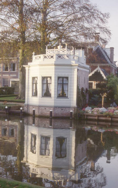 a garden cottage at the water's edge